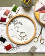 Load image into Gallery viewer, Embroidery kit with embroidery hoop, pattern, embroidery floss of varying colors, and embroidery needles
